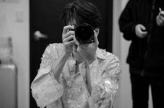 a photograph of wonwoo holding a camera as if he's taking a photo of the person who took this photograph.